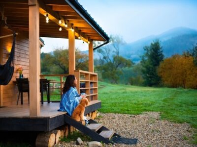 Woman,with,dog,resting,on,the,terrace,mountain,chalet,at