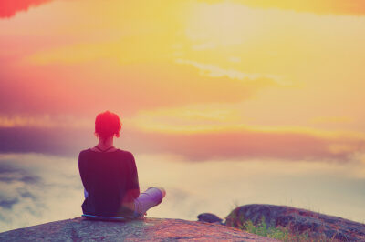 Young,woman,sitting,enjoying,peaceful,moment,of,beautiful,colorful,sunset.